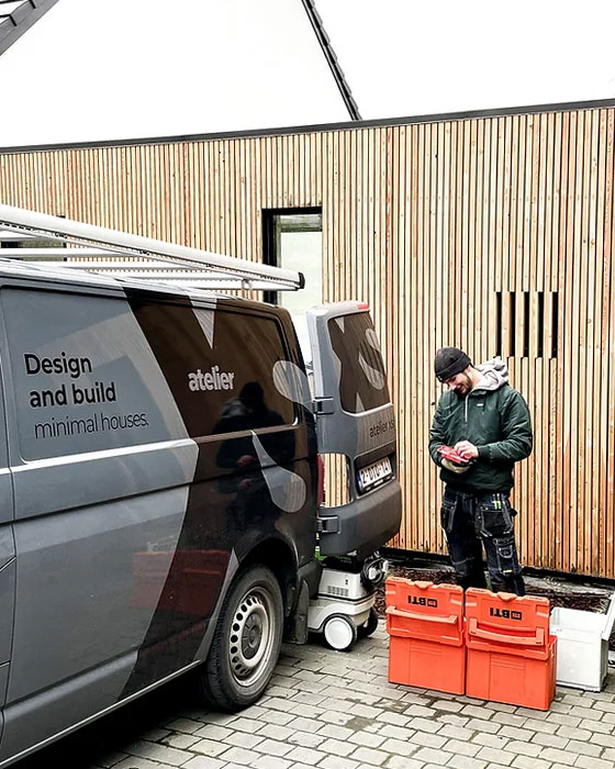 équipe devant façade en bois dans la région de Liège