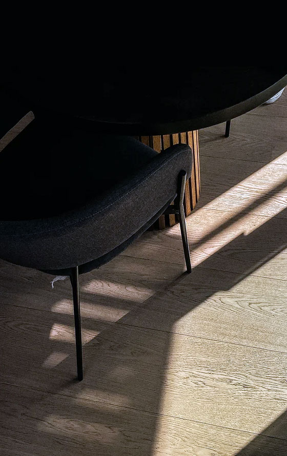 sol parquet avec reflet du soleil et chaise noire