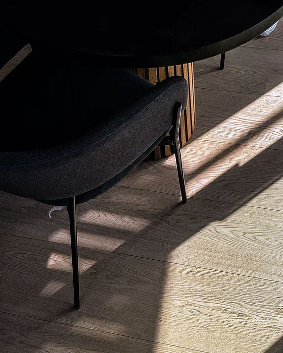 sol parquet avec reflet du soleil et chaise noire