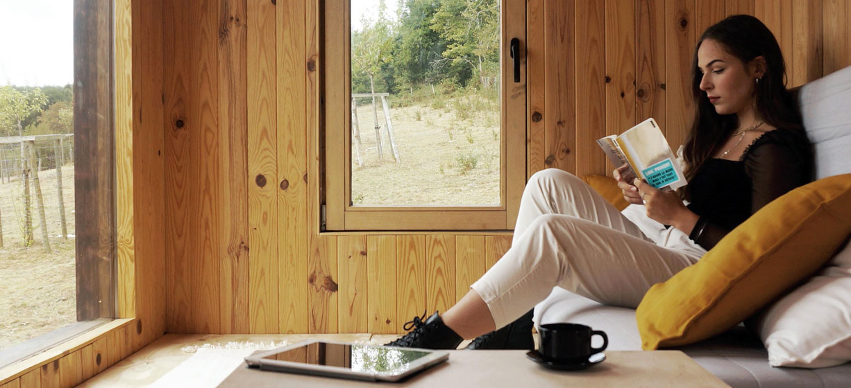 une fille lit un livre dans une tiny house