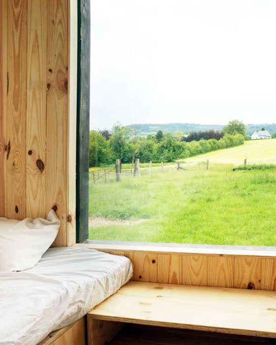 chambre d'une tiny house en bois avec vue sur la campagne en province de Liège